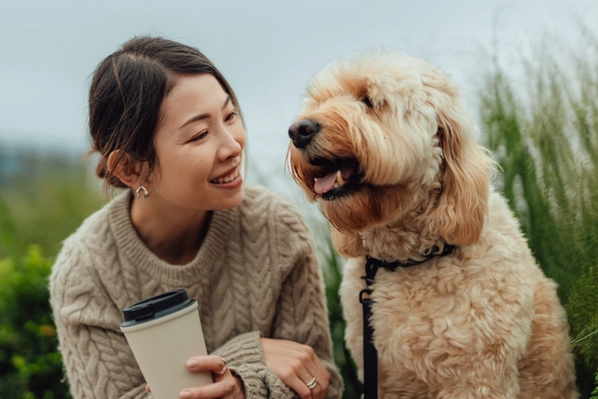 A woman kneeling down beside her dog